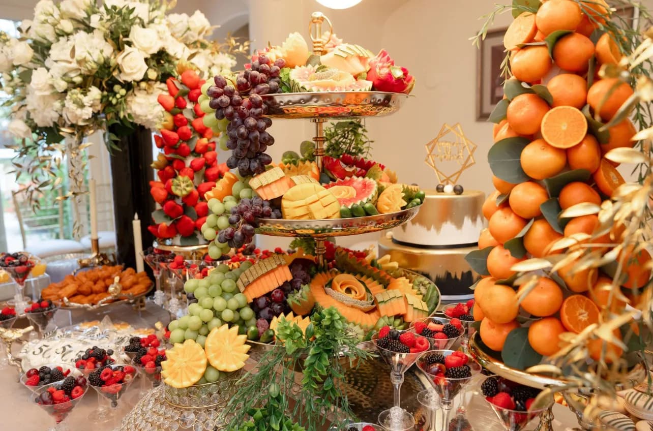 L’Amore fruit and sweets table with strawberry, orange, grape, and melon displays